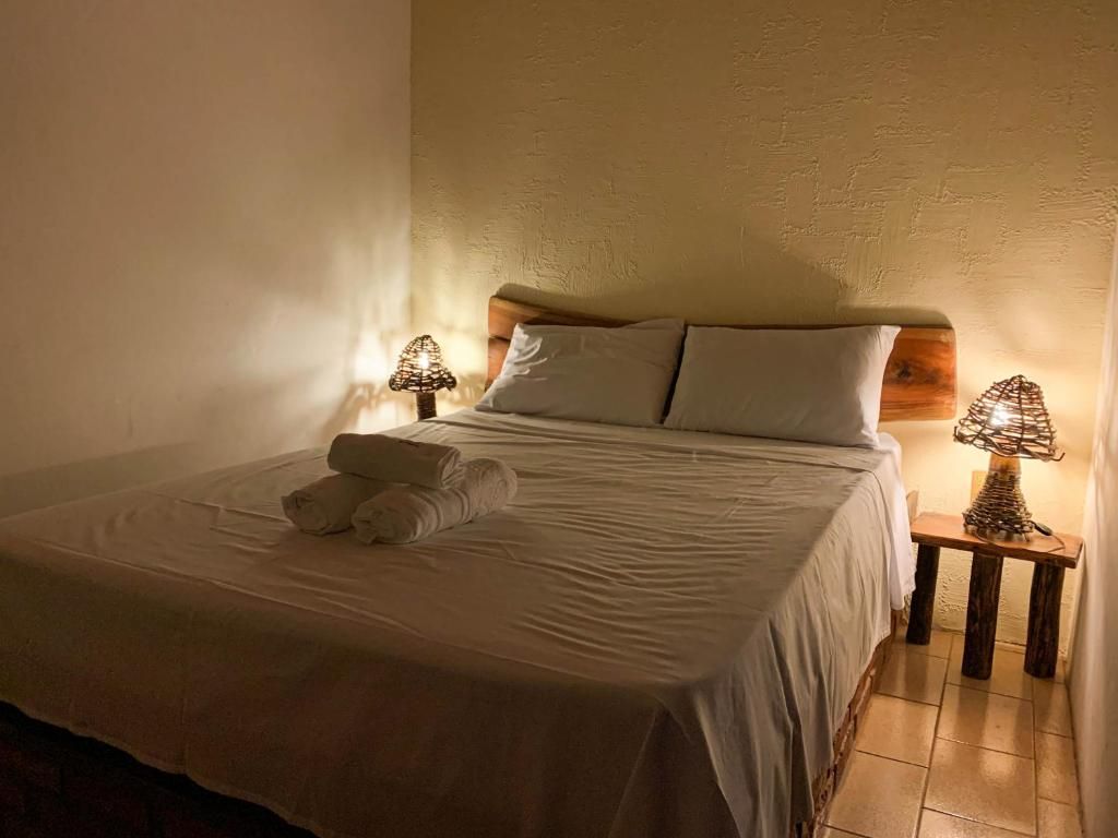 Cama arrumada com toalhas e luz quente
